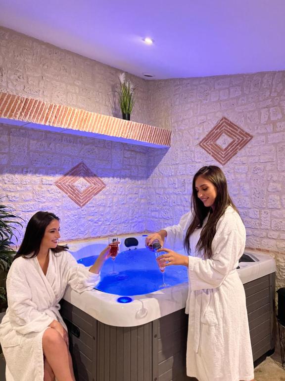 圣耐克森Suite Privative Jacuzzi Sauna de la Villa Del Castagnol的两间女性使用带浴缸的浴室