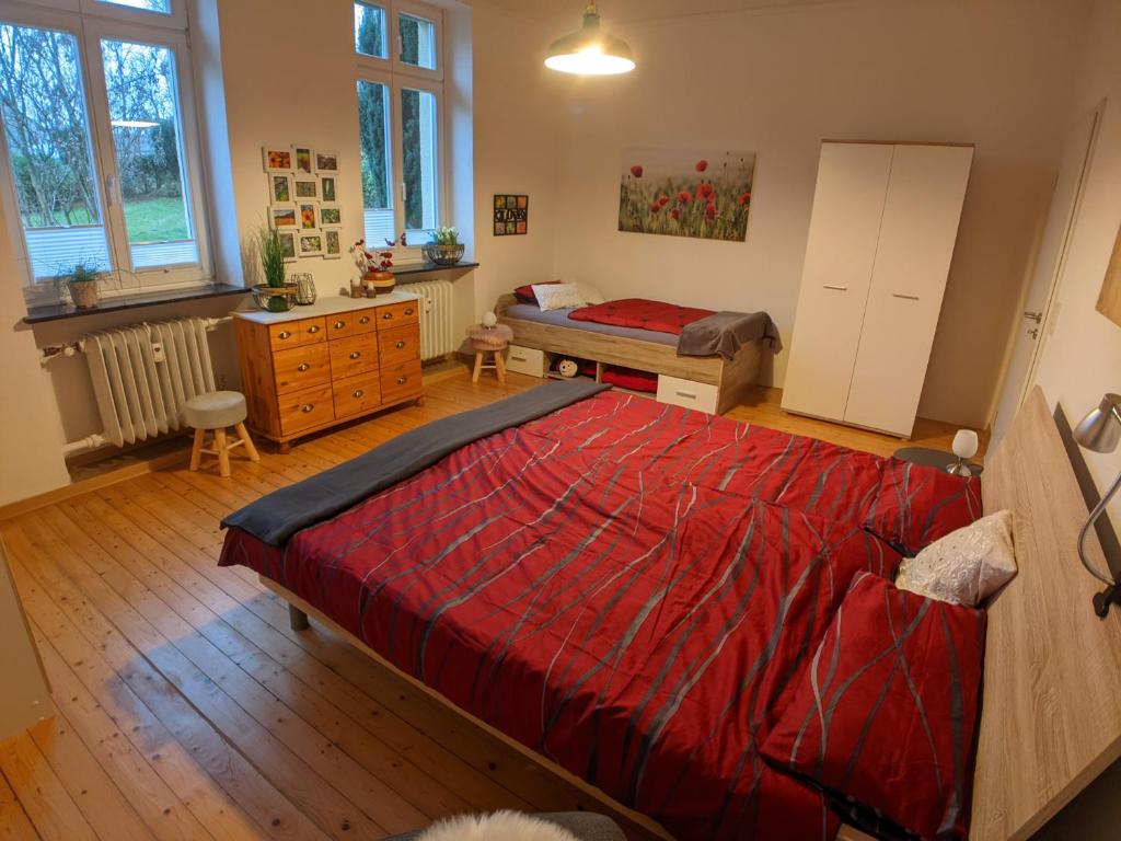 贝尔恩卡斯特尔-库斯Ferienwohnung Gartenblick的一间卧室配有红色的床、梳妆台和专栏。