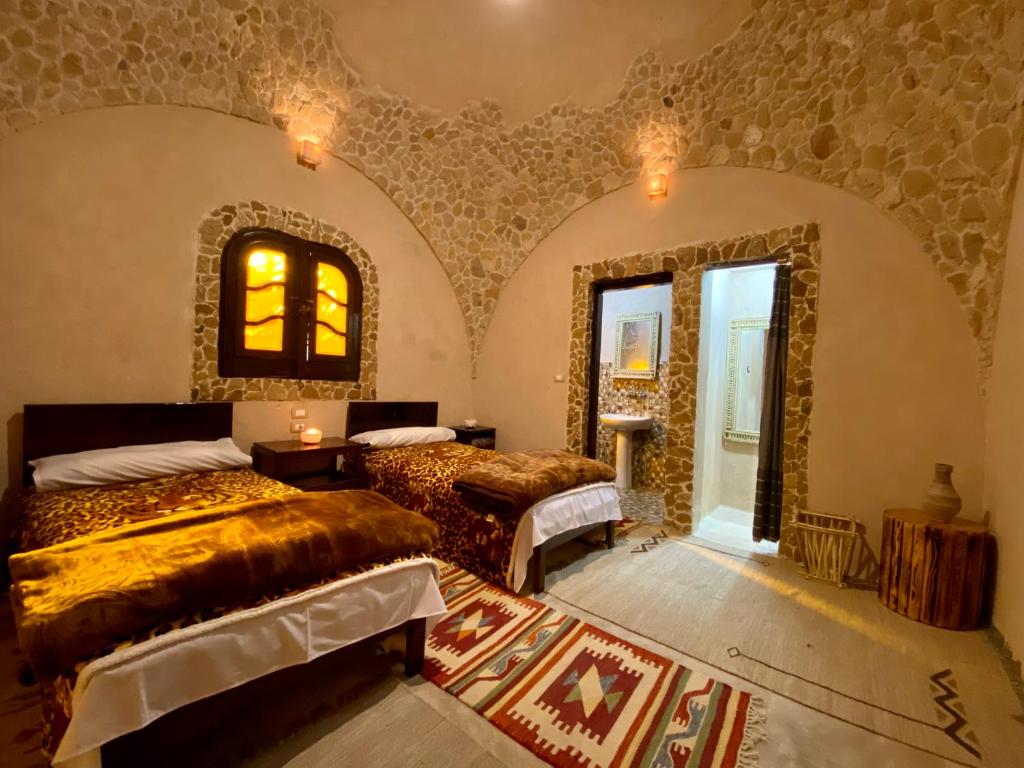 锡瓦Grand Siwa的一间卧室设有两张床,墙上设有一面镜子