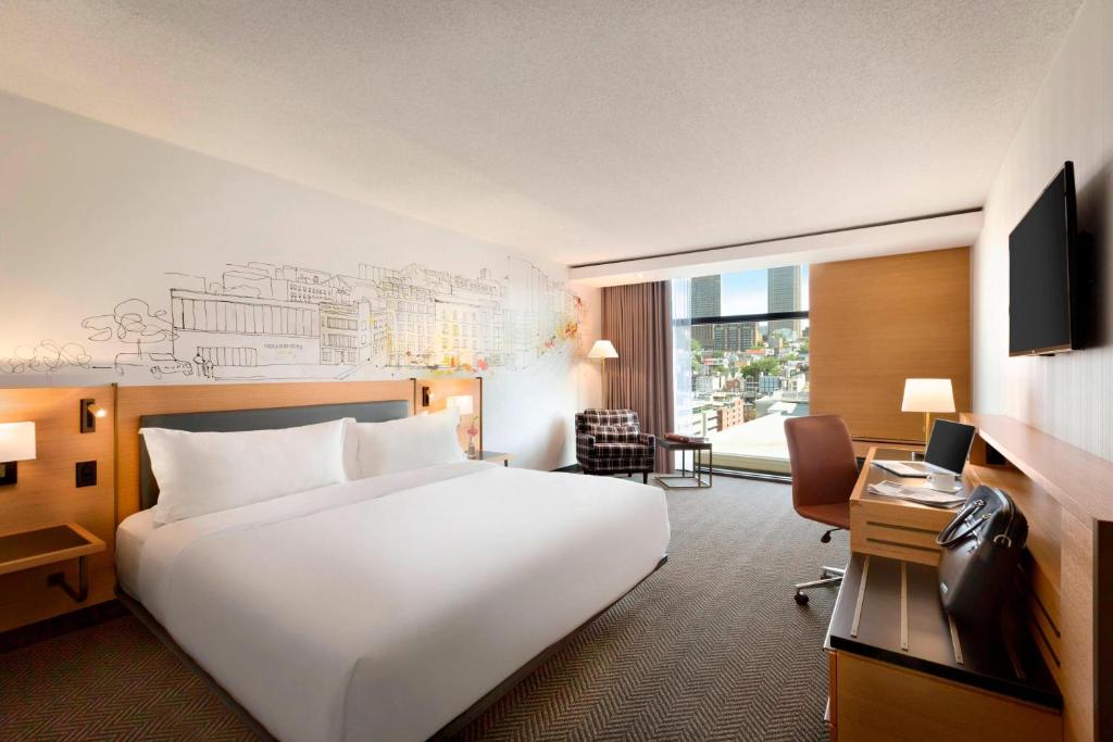 魁北克市魁北克臻品之选PUR酒店的酒店客房设有一张白色大床和一张书桌