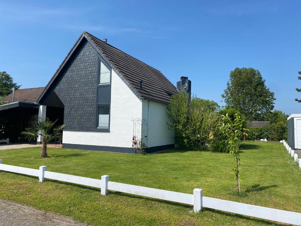 布勒伊尼瑟Family vacation in a spacious and comfortable holiday house的前面有白色围栏的小房子