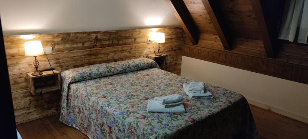 贝特兰贝特兰酒店的一间卧室配有床、两个灯和两张桌子