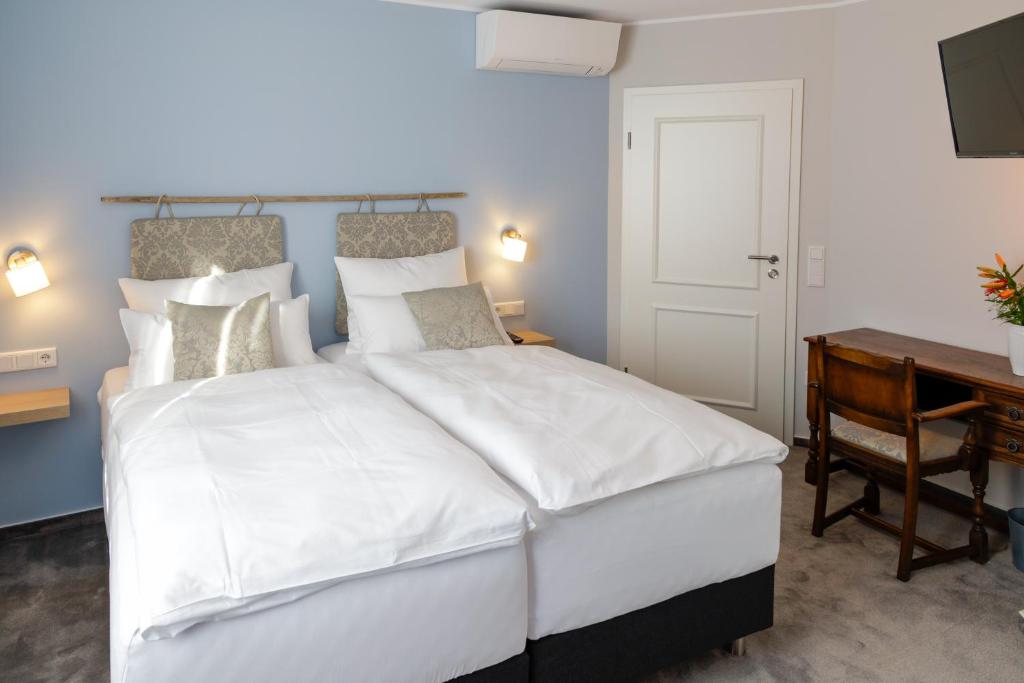 塞海姆-尤根海姆Hotel Brasserie Chaussee的卧室配有一张白色大床和一张书桌