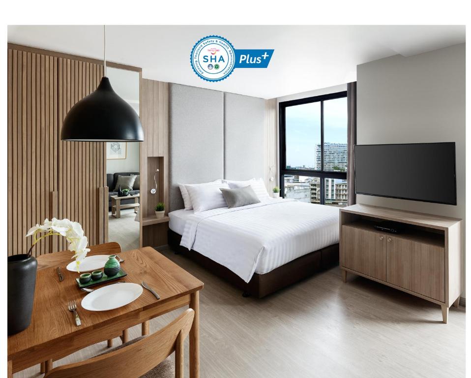 是拉差拉差思马德拉公寓式酒店的酒店客房设有一张床、一张书桌和一台电视机。