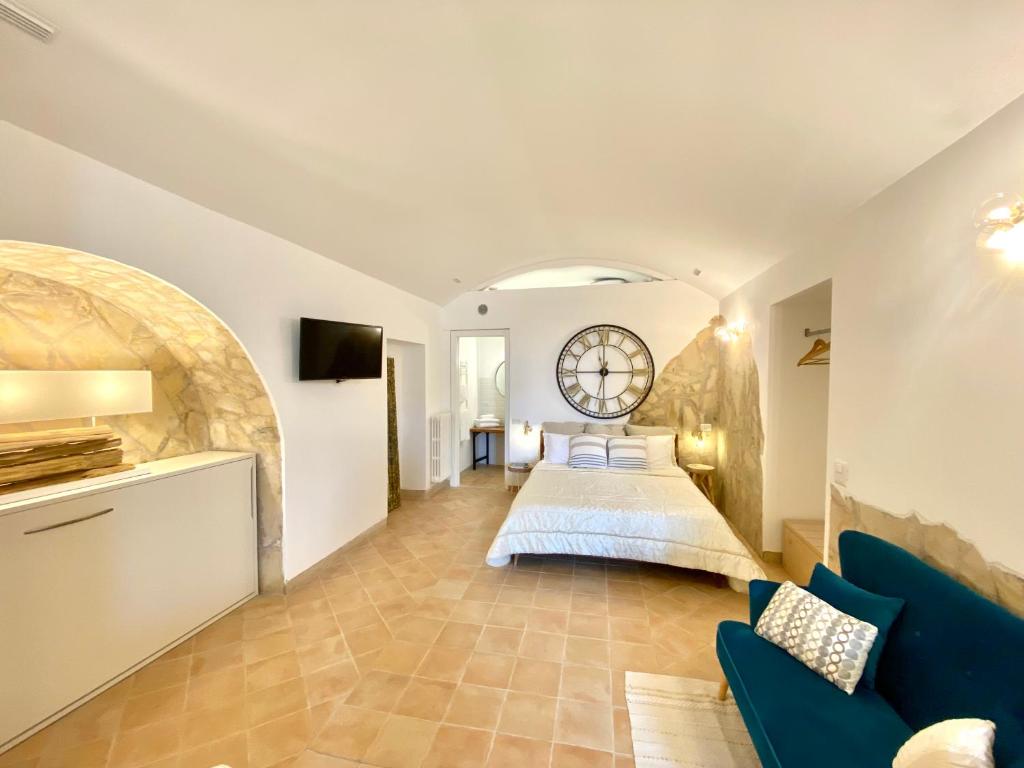 马泰拉Il Sorriso Dei Sassi Rooms的卧室配有一张床,墙上挂着大钟