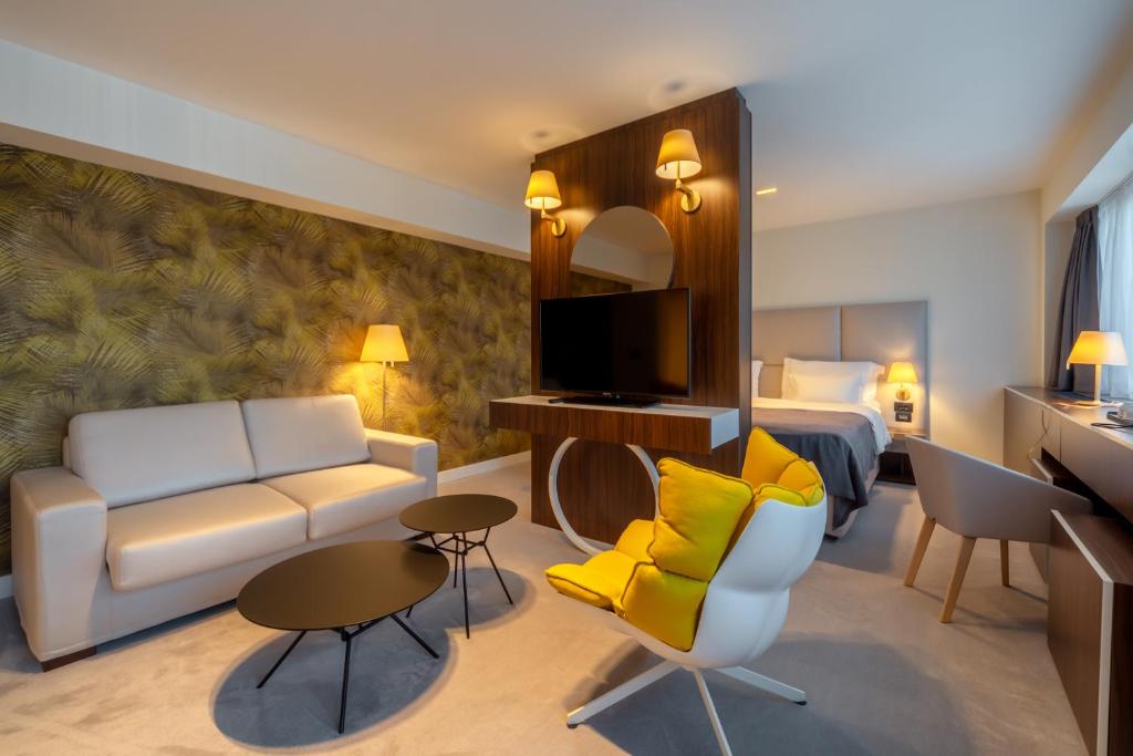 巴尔HOTEL AGAPE的酒店客房设有一张沙发和一张床