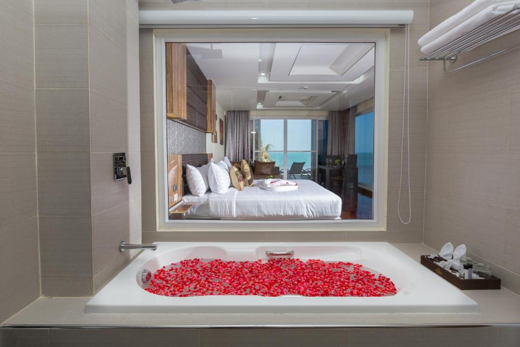 拉迈Royal Beach Boutique Resort & Spa Koh Samui - SHA Extra Plus的浴室配有装满红玫瑰的浴缸