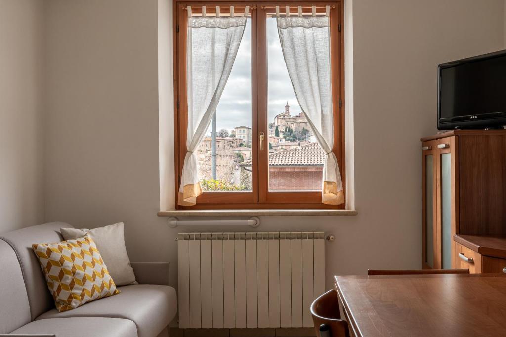 托里塔迪谢纳Casa in Chiana的带沙发和窗户的客厅