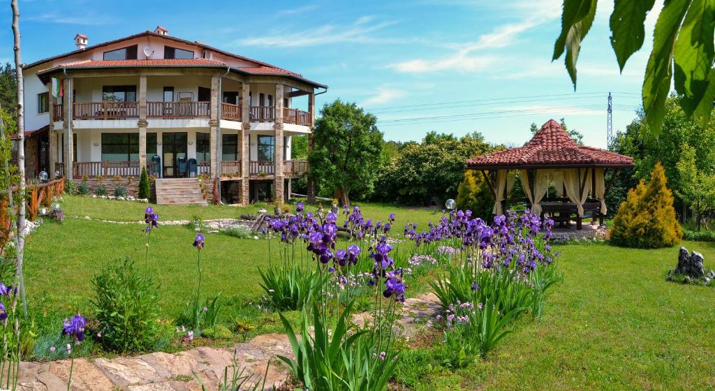 上奥里亚霍维察Park Hotel Djevana的一座带紫色花卉花园的房屋