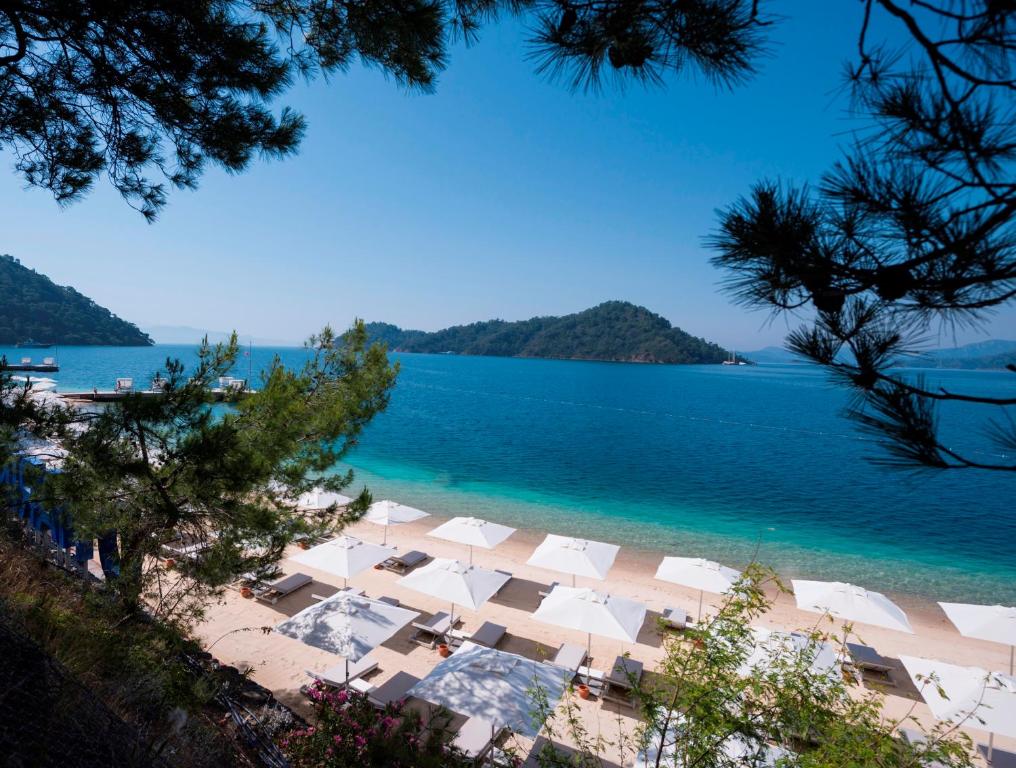 戈西克D Resort Gocek Special Category的享有海滩美景,配有白色遮阳伞和水
