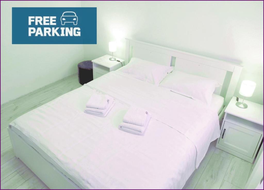 皮亚特拉-尼亚姆茨Smart Apartament的卧室配有白色的床和2条毛巾