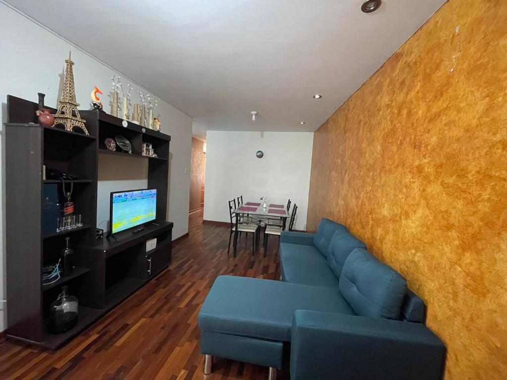 特鲁希略Exclusivo Apartamento en el corazón de Trujillo的客厅配有蓝色的沙发和桌子