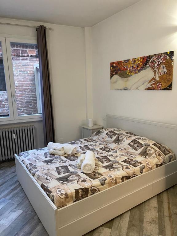 罗维戈BONBON的卧室内的一张床铺,墙上有绘画作品