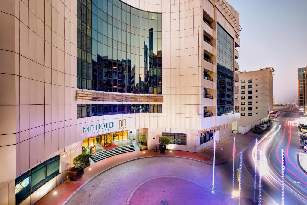 迪拜MD Hotel By Gewan的一座大型建筑,前面设有一个游泳池