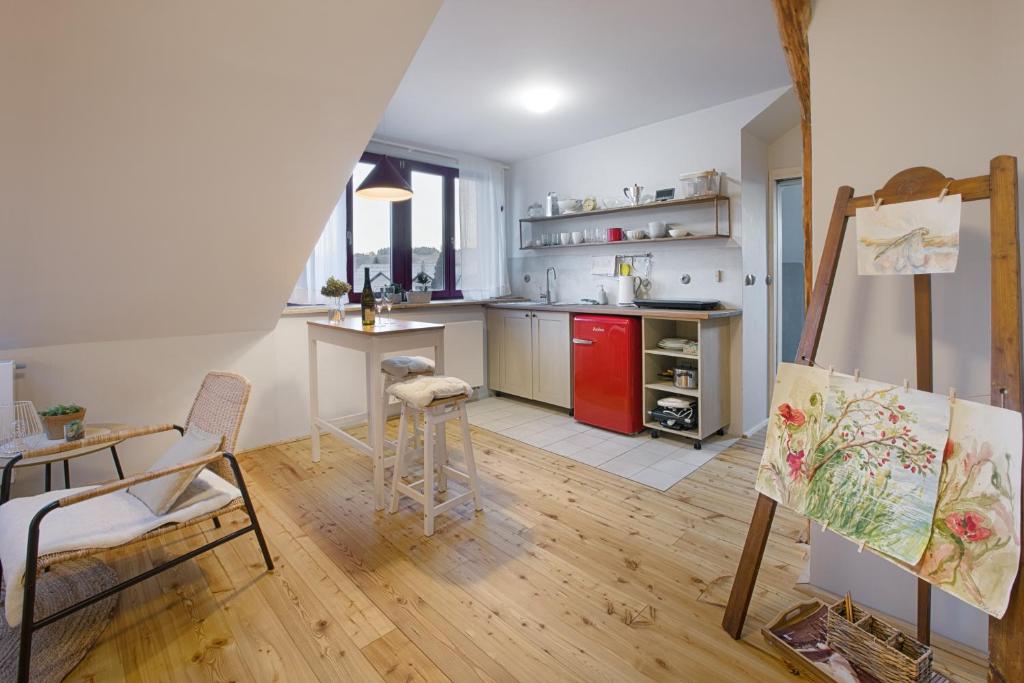 赫林斯科Apartmány v domečku的客房设有带桌子和绘画的厨房