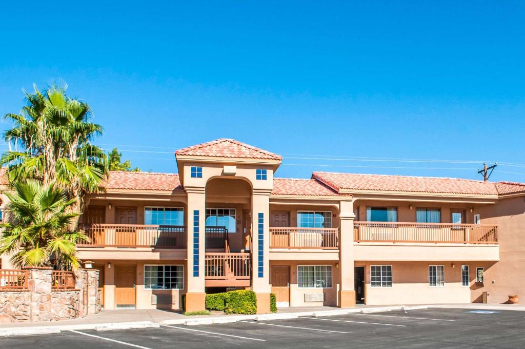 拉斯克鲁塞斯Quality Inn & Suites Las Cruces - University Area的一座棕榈树大型公寓楼