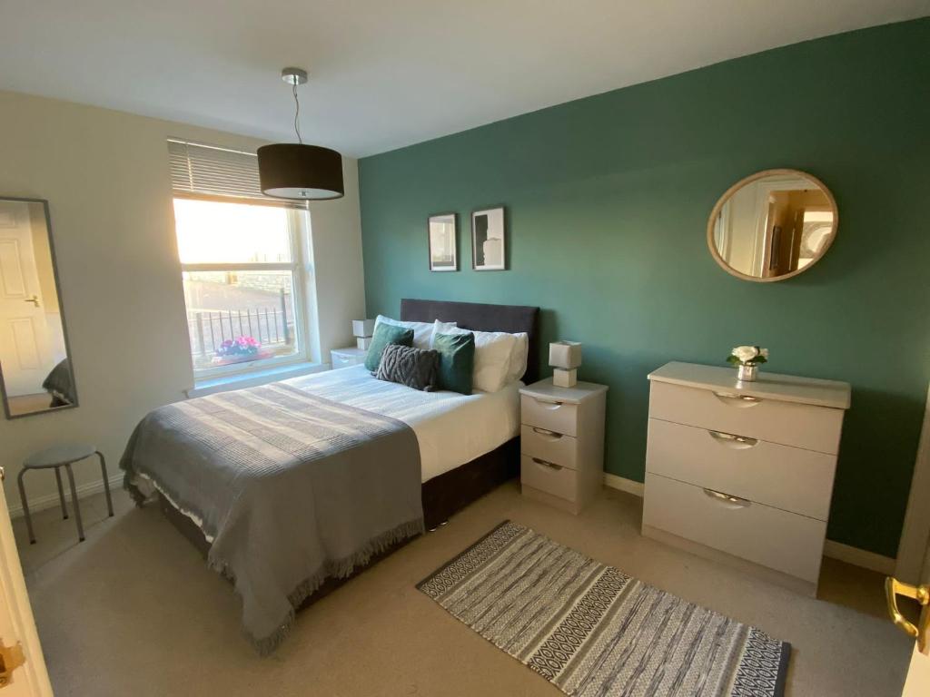 柯科迪Maltings Apartment - Spacious 2 Bed Ground Floor Apartment的一间卧室配有一张床、镜子和窗户