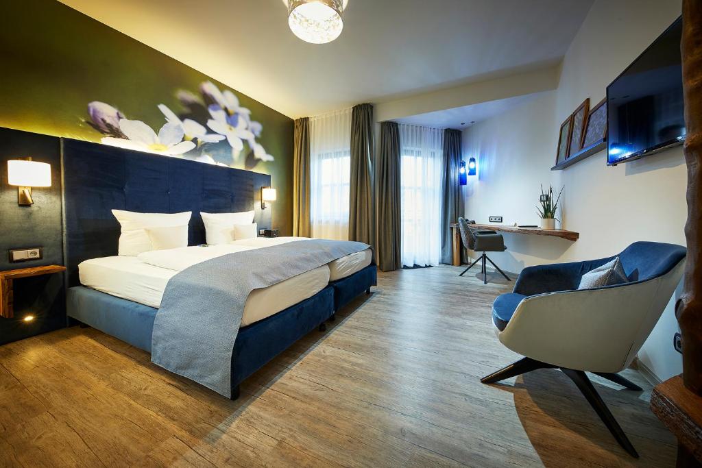 梅德巴赫穆勒兰德酒店的配有一张床和一把椅子的酒店客房