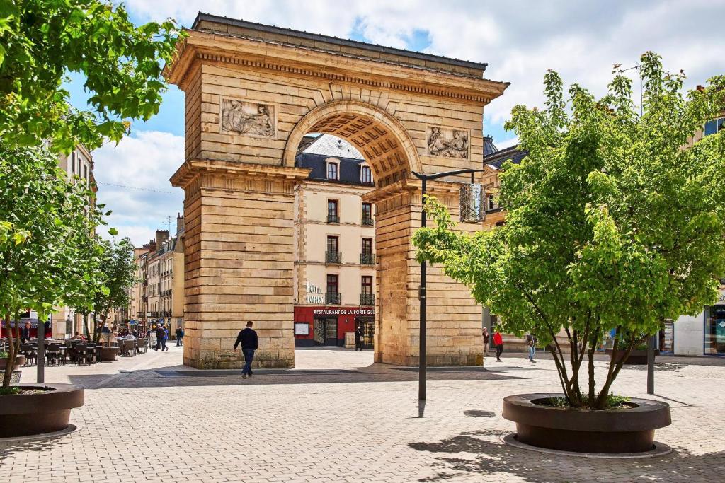 第戎Logis Hotel Darcy Dijon Centre的街道中间有拱门的建筑