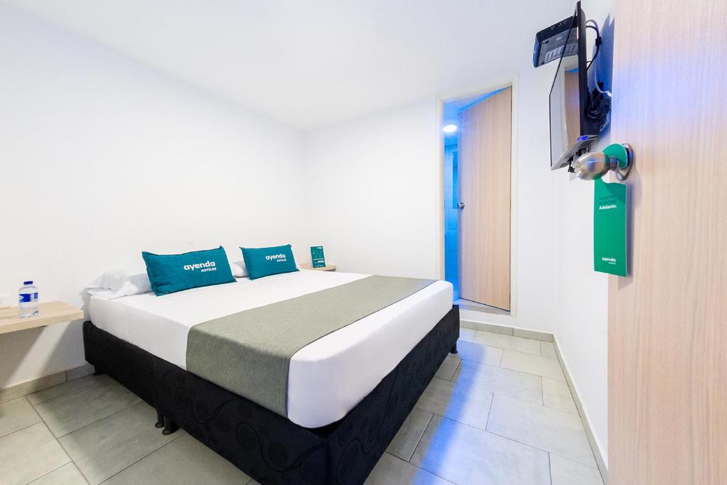 马尼萨莱斯Ayenda Panamericana的卧室配有一张床铺,墙上配有电视