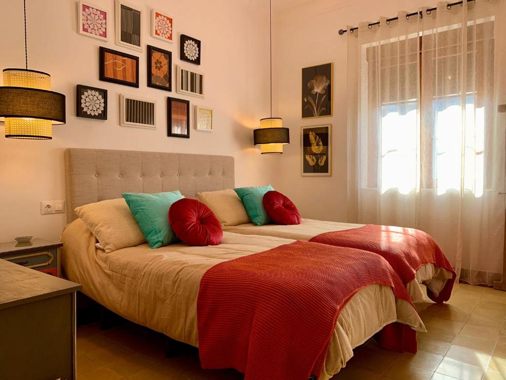蓬费拉达Alojamiento estilo Boho con mucho encanto的一间卧室配有两张带彩色枕头的床和窗户。