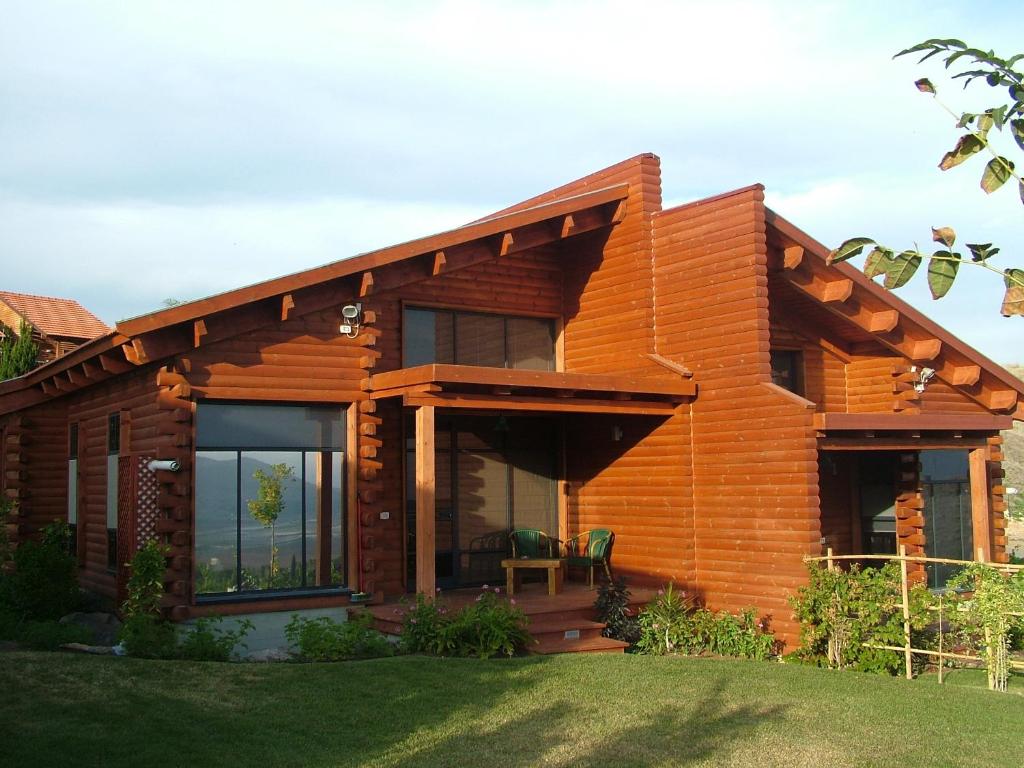 ‘En H̱arodEin Harod Country Lodge的一座带大窗户和草坪的木屋