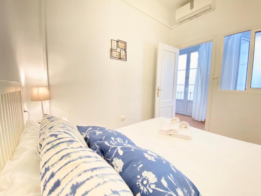 塞维利亚SuperB Apartment in downtown of Sevilla ,parking optional, Top !!的一间卧室配有一张带蓝色和白色枕头的床
