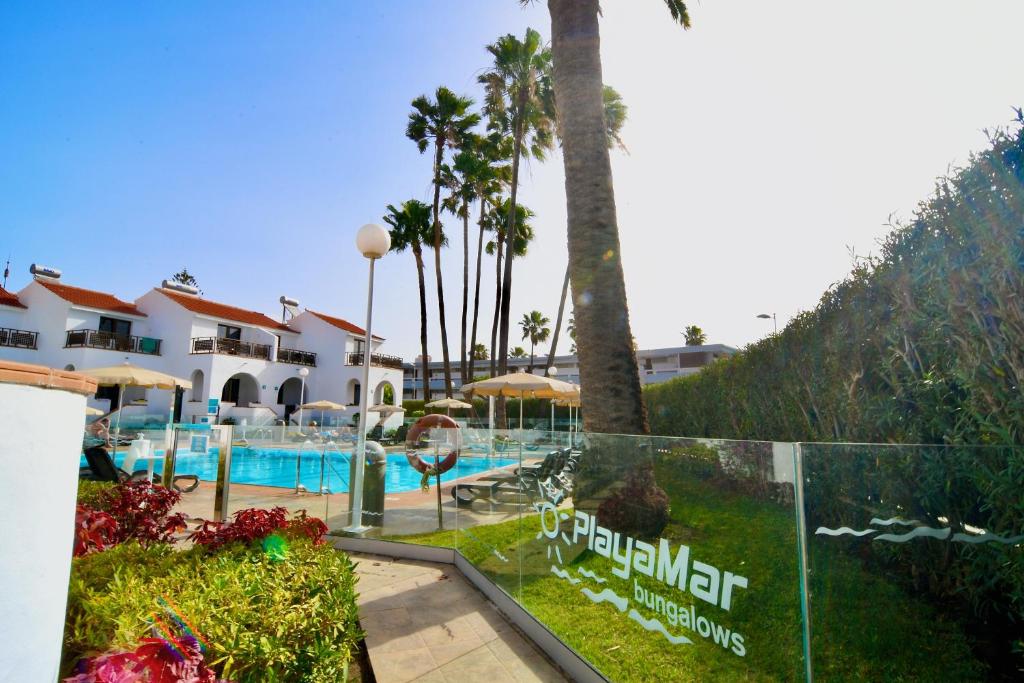英格兰海滩普拉亚玛尔洋房酒店的一个带游泳池和棕榈树的度假村