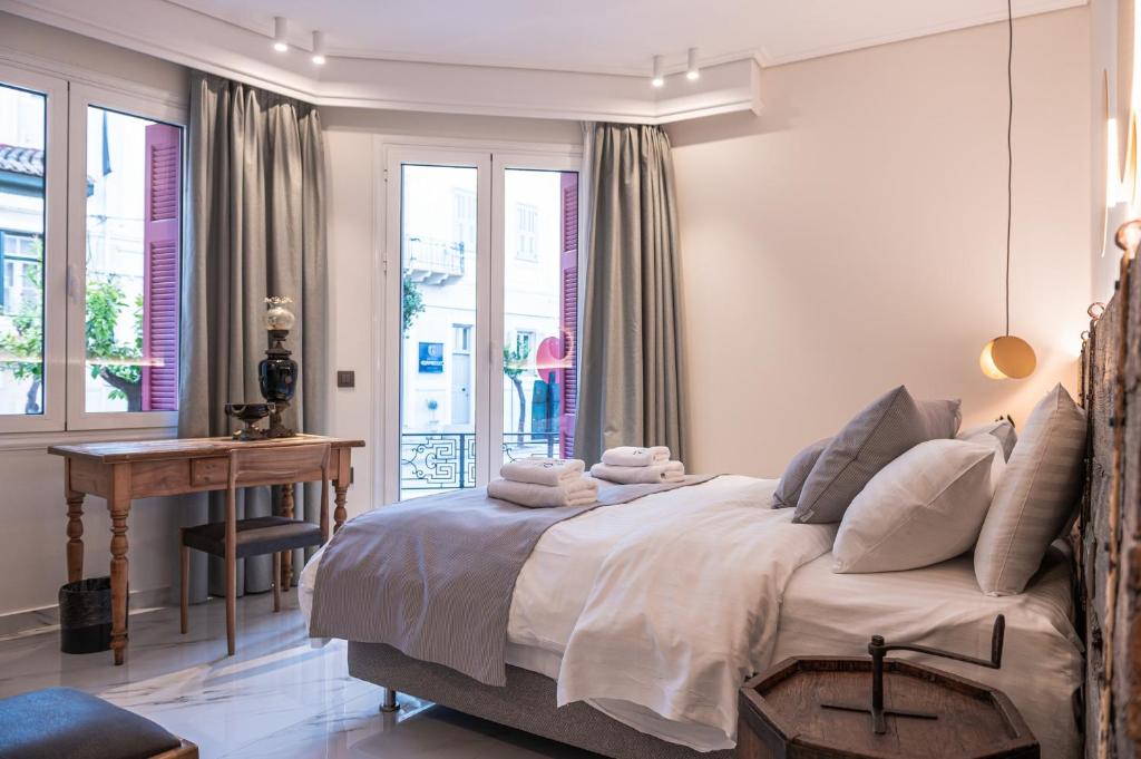 纳夫普利翁Silo Luxury Rooms的卧室配有一张床、一张书桌和窗户。