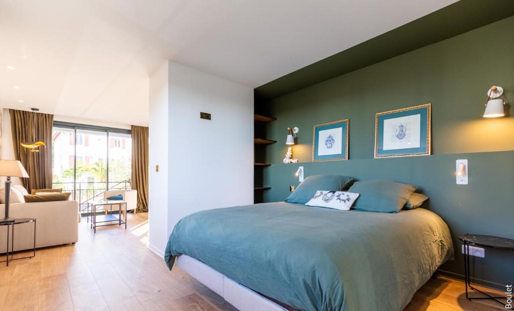 比亚里茨VILLA BIBI CHERI Elégante Suite de 35 M2的一间卧室设有一张床和绿色的墙壁