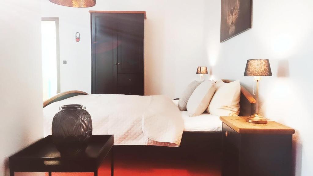 RochlitzStadthotel的一间卧室配有一张床和一张带台灯的桌子