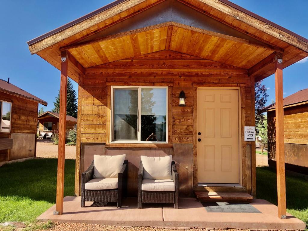 哈奇Mountain Ridge Cabins & Lodging Between Bryce and Zion National Park的一个带两把椅子的木制凉亭和白色门