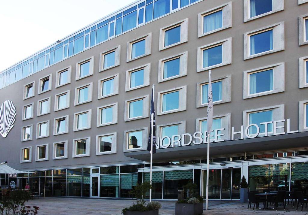 不来梅港Nordsee Hotel City的一座酒店大楼,前面有标志