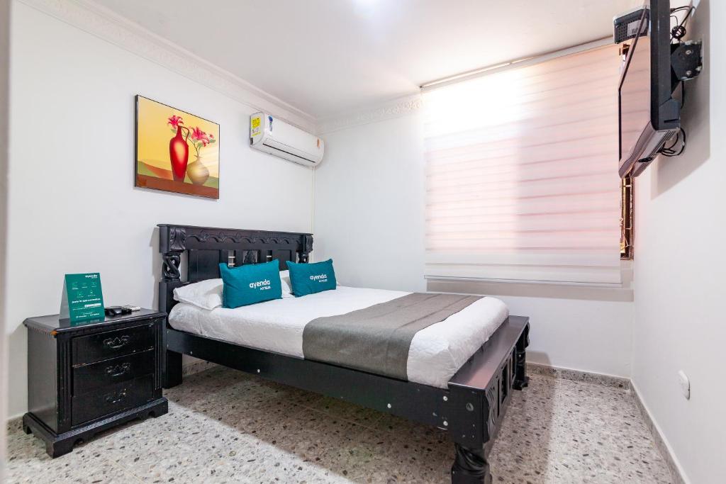 巴耶杜帕尔Ayenda Orquidea 19的一间卧室配有一张带蓝色枕头的床和一扇窗户。