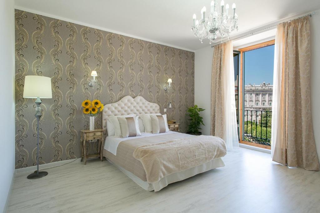 马德里马德里中央皇宫旅馆的一间卧室设有一张床和一个大窗户