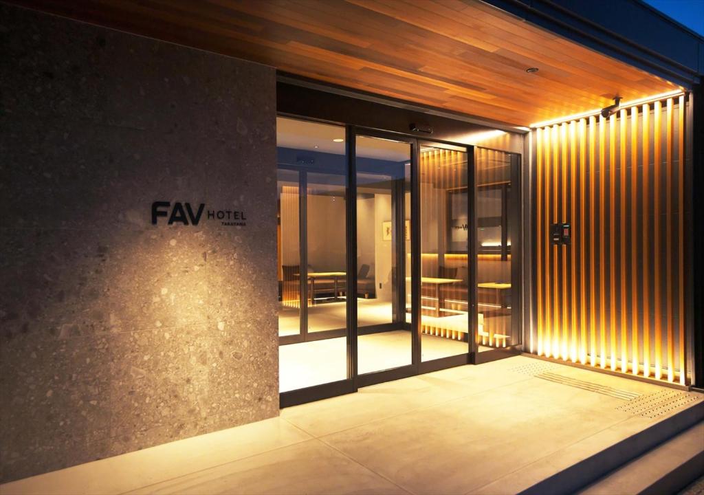 高山FAV HOTEL HIDATAKAYAMA West的带有玻璃门和灯的建筑物入口