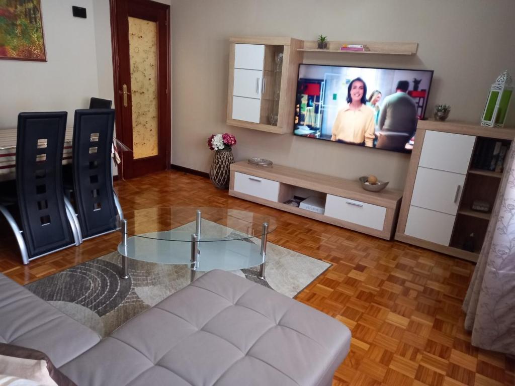 奥维多Apartamento Araceli próximo a clínica Oftalmológica Fdez Vega的客厅配有玻璃桌和电视