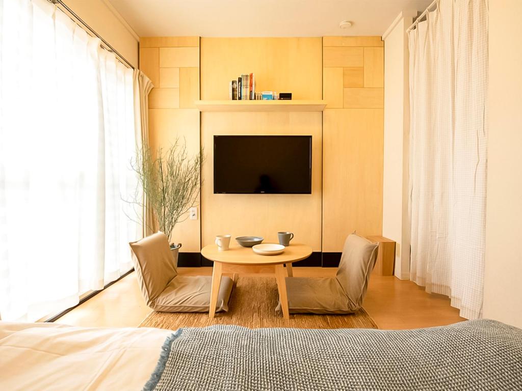 仓敷生命领域公寓的一间卧室配有桌椅和电视