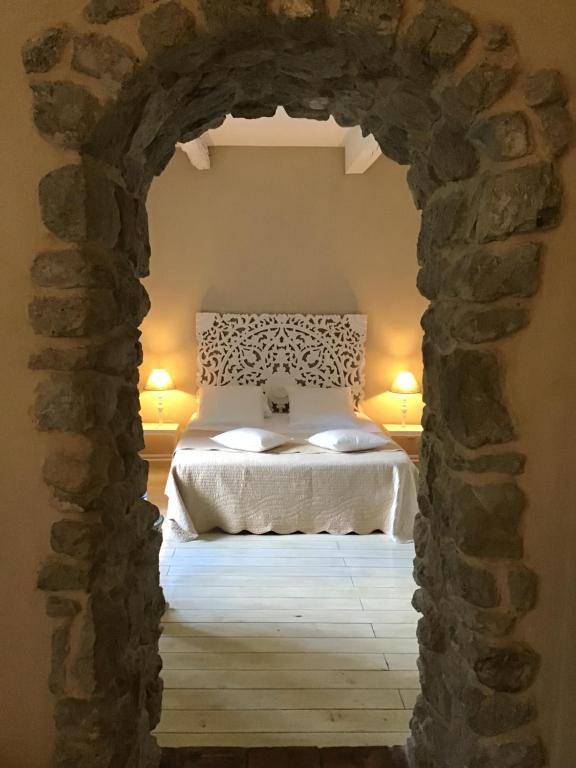 卡尔卡松奥克斯昂格加迪安斯酒店的卧室设有一张通过石拱门的床铺