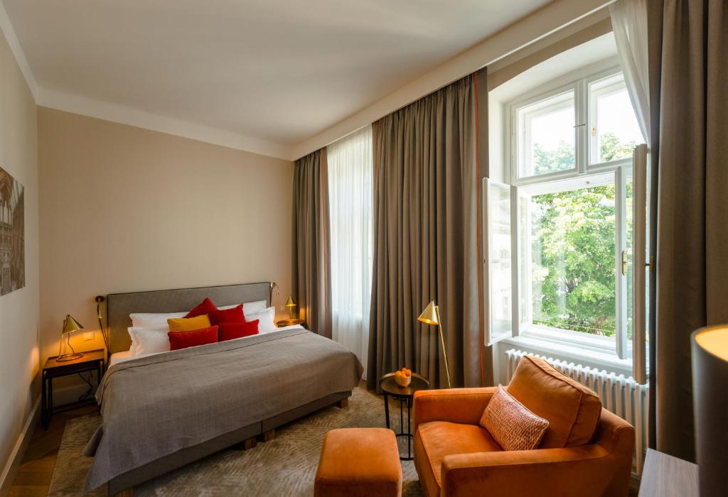 维也纳Roosevelt Stadthaus的卧室配有床、椅子和窗户。