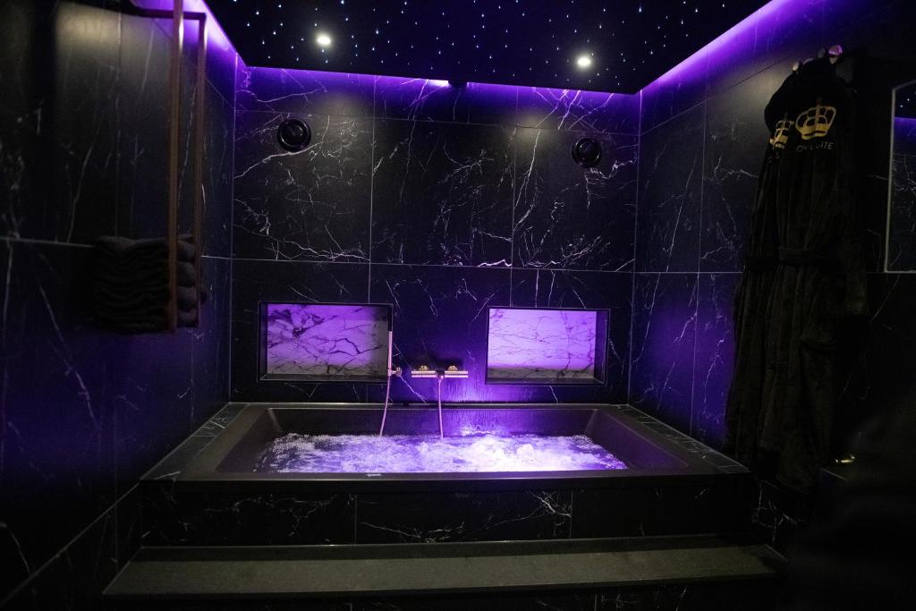 斯赫拉芬赞德Royal Suite的客房内的紫色照明浴缸