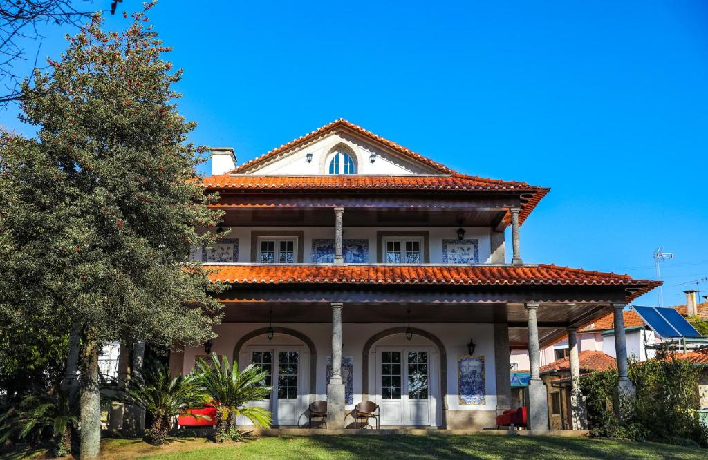 圣玛丽亚大德费拉Quinta do Candeeira的一座大型白色房屋,设有红色屋顶
