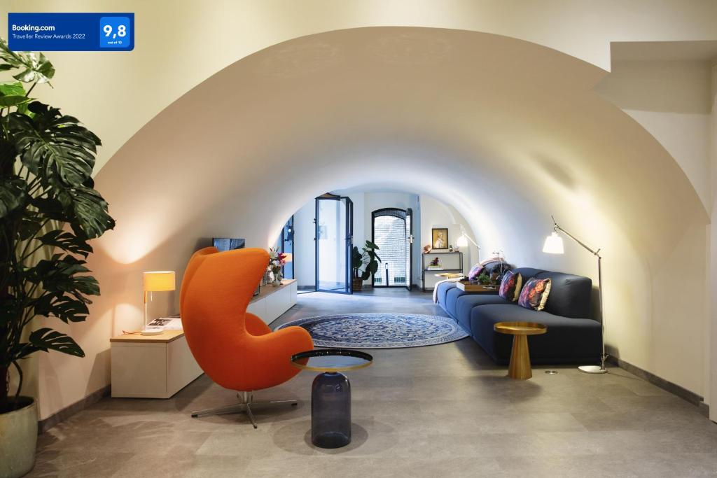 乌得勒支LOFT 188 Luxury Apartment Hotel的客厅配有蓝色的沙发和橙色的椅子