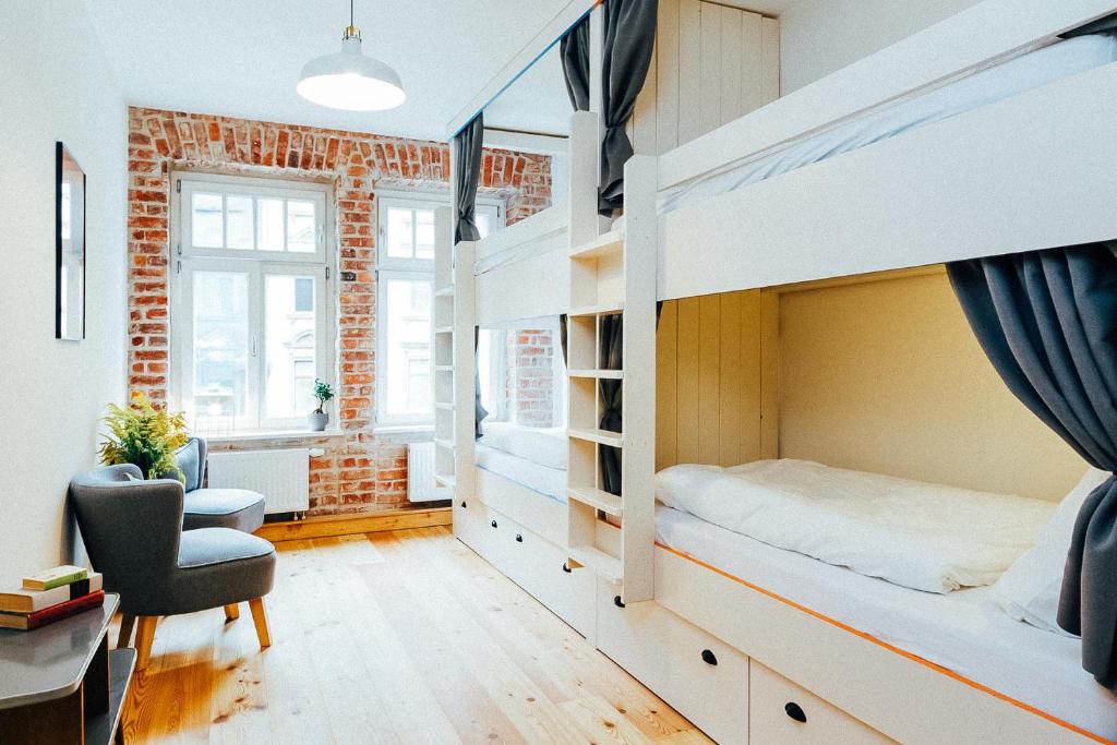 莱比锡Hostel Multitude的一间卧室配有一张双层床、一张桌子和一把椅子