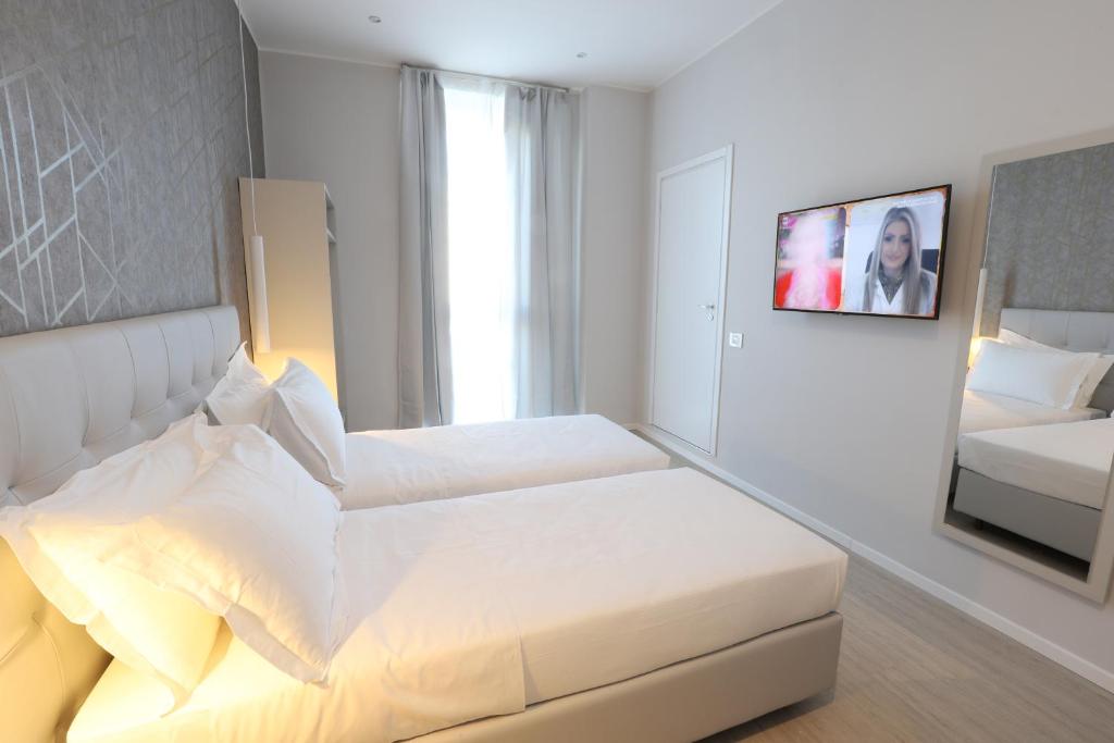 米兰Cadorna Luxury Hotel的白色卧室配有床和镜子