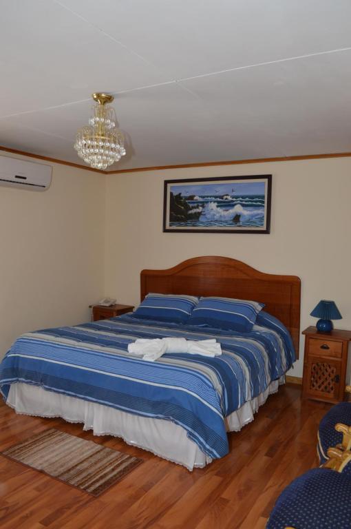 SalamancaHotel My House的一间卧室配有一张带蓝色床单和吊灯的床。