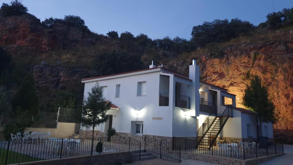 奥萨德蒙铁尔Casas rurales La Carrasca的山前带楼梯的白色房子