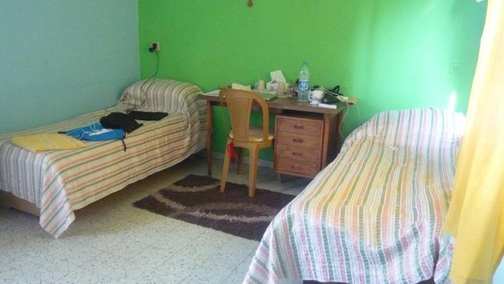 伯利恒B&B at Palestinian home / Beit Sahour的一间卧室配有两张床和一张书桌