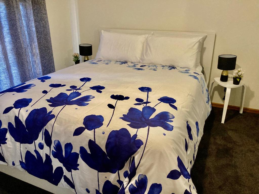 金斯科特CandE on Buller的一张带蓝色和白色棉被的床