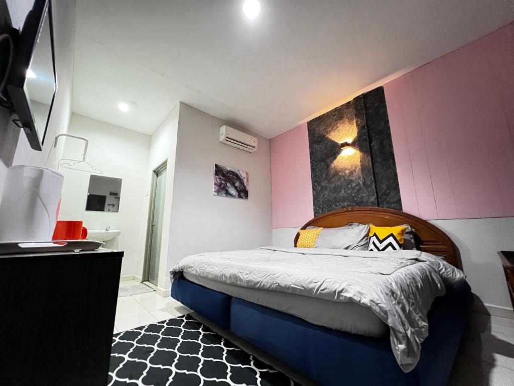 珍南海滩Little Chenang Cottage Motel Langkawi的一间卧室配有一张床和粉红色的墙壁